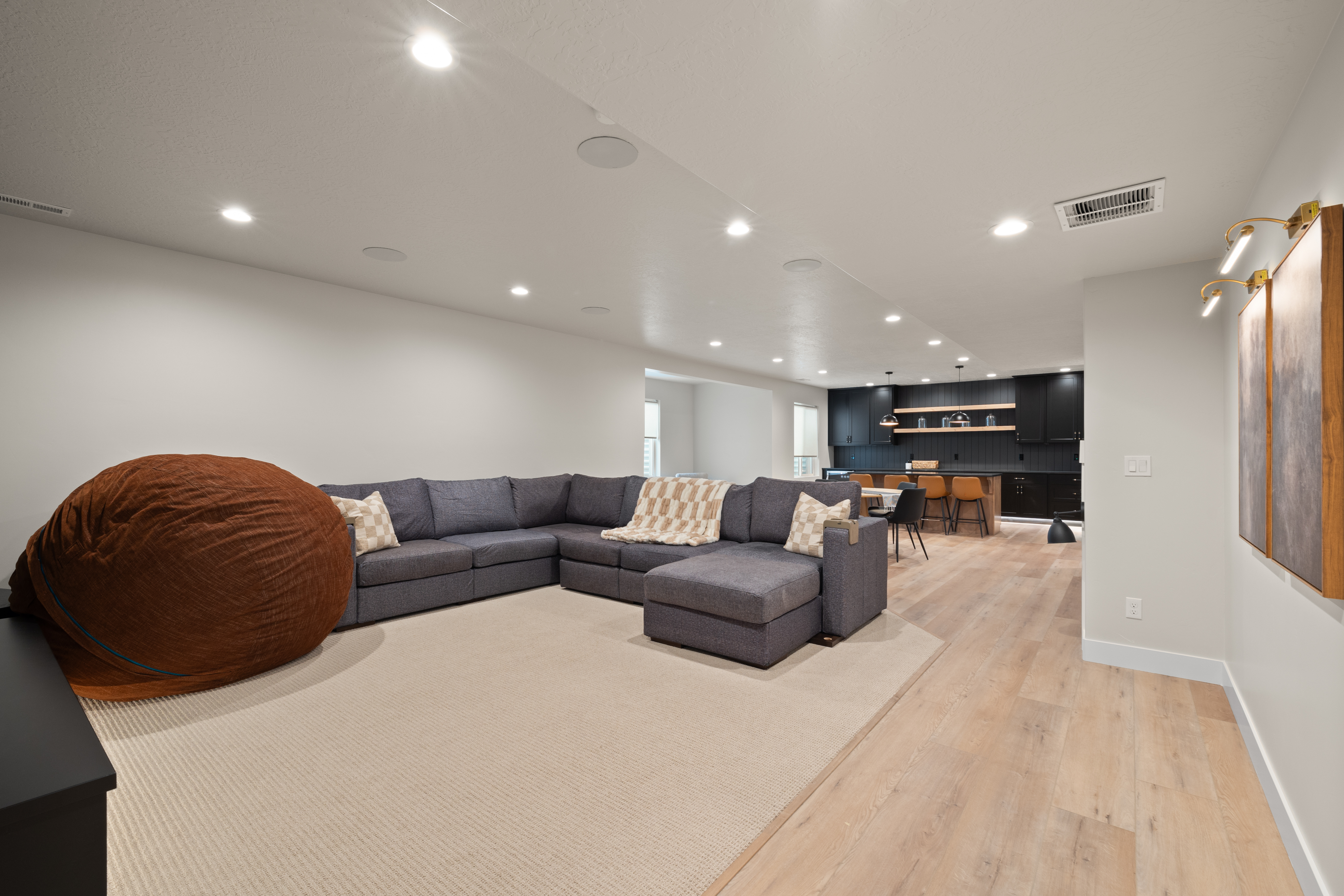 Finished basement living space with kitchen bar and lounge seating